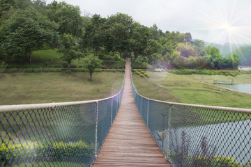 Obraz premium The rope bridge in the park directly onto the solitary island on the lake