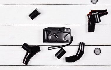 Vintage plastic camera with photographic film on a white wooden table.
