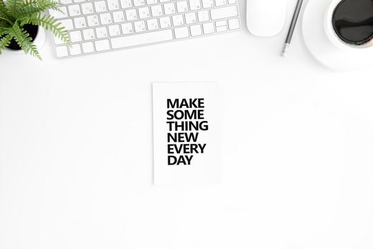 flat lay with make something new every day motivational quote in diary, computer mouse and keyboard isolated on white