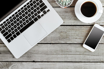 top view of wireless digital devices and coffee cup on wooden background