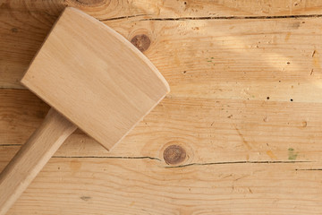 Wooden Hammer/Wooden hammer on a wooden carpenter’s table. Great for any text, enough copy space