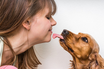 Cute dog licking face of woman