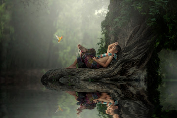 Happiness of a peasant boy sleeping in a tree in the forest.