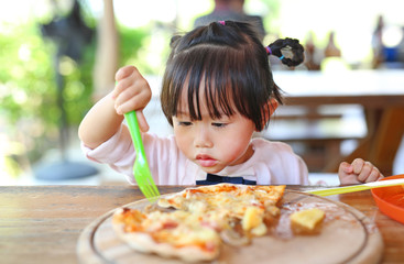 Little child girl enjoy eating pizza.