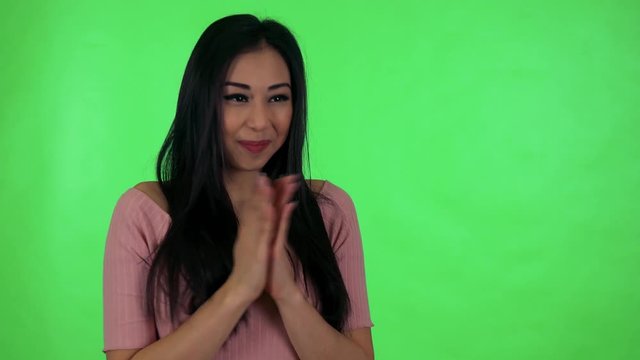 young attractive asian woman rejoices - green screen studio