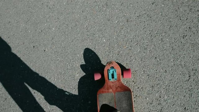 Man riding a longboard, a plan view on the move, close-up, first-person view. Lens, flare effect 20s 4k