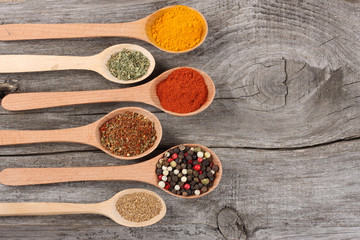 spices in spoon on old wood background