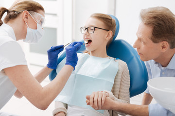 Concentrated caring dentist making sure patients teeth are healthy