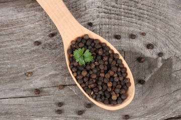 black pepper. peppercorns in wooden spoon on wooden background with copy space. top view