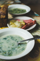 Cream soup with herbs in white plate. Shallow depth of field.