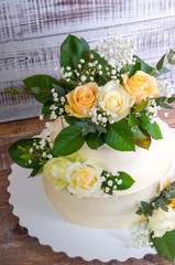 two-tiered wedding cake with roses eucalyptus