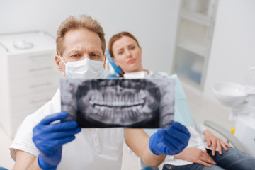 Dedicated learned dentist studying patient jaw scan