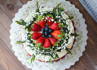 two-tier cream cheese wedding cake with blueberries and strawberries