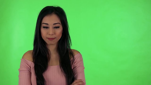 young attractive asian woman agrees (move with head on yes) - green screen
