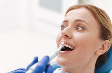 Sweet emotional woman sitting in dentists chair