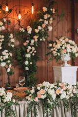 Wedding table served banquet decorated with flowers and plants, retro lamps on a wooden background