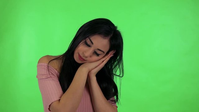 young attractive asian woman gets up and stretches - green screen studio
