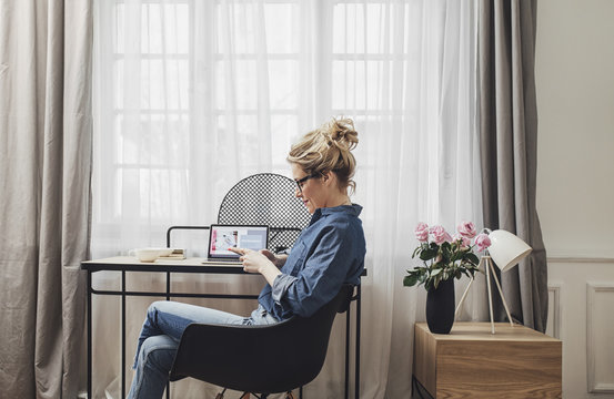 Woman using smartphone in home office