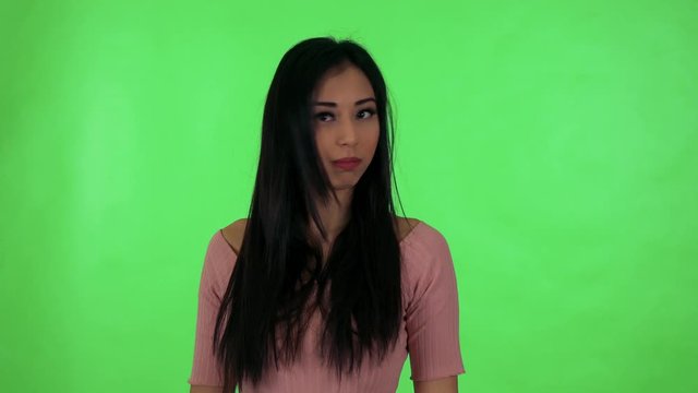 young attractive asian woman disagrees - green screen studio