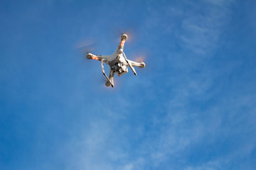White drone flying in blue sky 