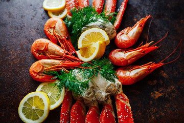 Beautiful crab claw with shrimp on a background of lemon and herbs