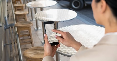 Businesswoman taking picture with phone in coffee shop