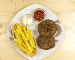 Hamburgers in a plate on wooden background - top view