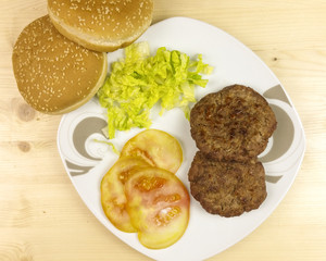 Hamburgers in a plate on wooden background - top view