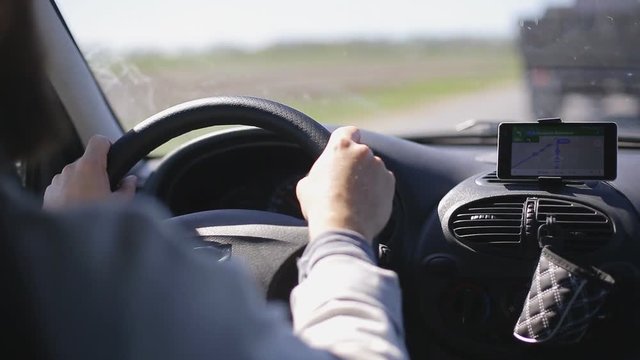 Man rides a car with a navigator on a smartphone