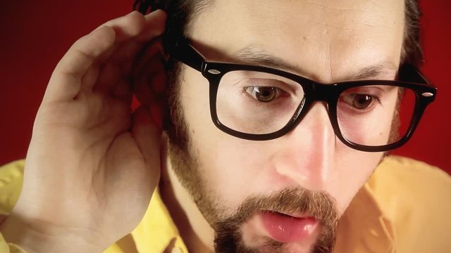 A funny ugly man spying and trying to hear a secret by dropping his ear near the viewer, acting surprised. Extreme close-up shot.
