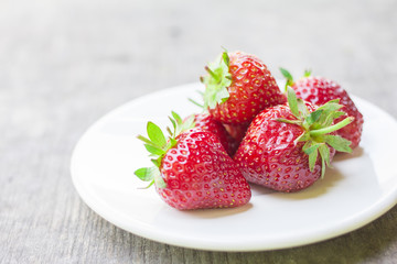 strawberry in a dish placed on the wood
