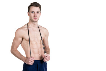 Fototapeta premium Healthy lifestyle and fitness. Handsome guy sports a physique, with a naked body, with a skipping rope in his hands, isolated on a white background. Horizontal frame