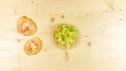 Making burger and chips on wooden background - top view