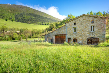 Fototapeta na wymiar French countryside. Typical old farm with mountains in the background in Vercors, France.