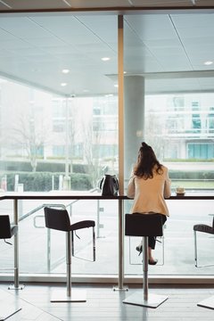 Businesswoman relaxing in office cafeteria