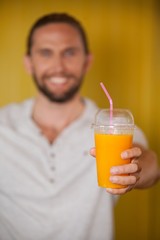 Fototapeta premium Male staff holding orange juice glass at organic section