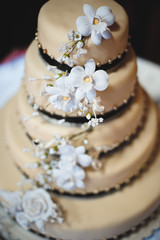 Obraz na płótnie Canvas beautiful golden wedding cake with flowers