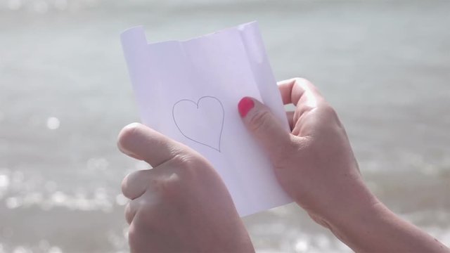 High quality video of paper with the message heart in hands in real 1080p slow motion 250fps More videos from this series in my portfolio