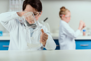 Fototapeta premium schoolchildren with science lab equipment in chemical lab, scientists kids group concept