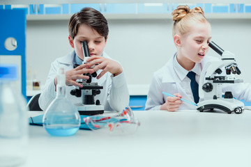Obraz premium schoolchildren with science lab equipment in chemical lab, scientists kids group concept
