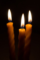 three big burning candles. Bright light on dark background. RIP darkness template. Birthday party. Romantic evening on Valentine.