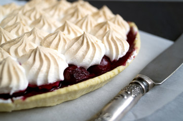 cherry tart with meringue on a white plate