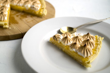 lemon tart with meringue on a white plate