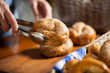 Hands of female staff holding sweet food with tongs