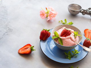 Home made strawberry ice cream in bowl with min leaves
