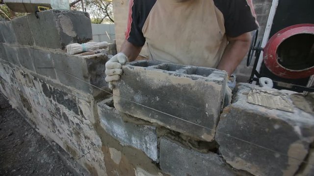 Rural man laying cinder blocks