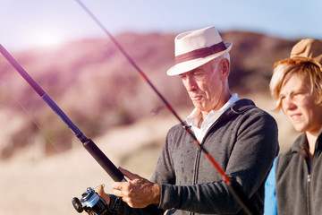 Senior man fishing with his grandson