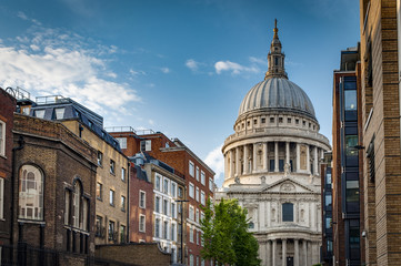St Paul cathedral seen from a narrow alley enclosed by brick buildings on a cloudy summer day in London, England,UK. St Paul’s is an important landmark of London
