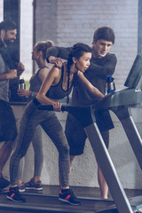 athletic young sportswoman running on treadmill at the gym, fitness couple gym concept