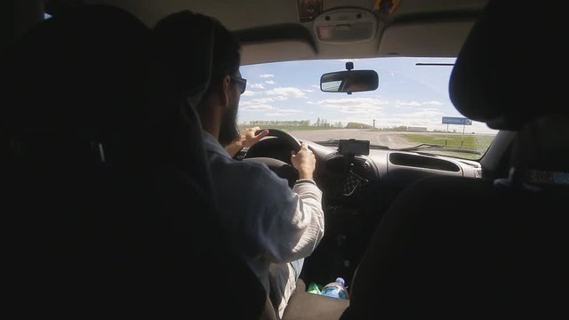 Man rides a car with a navigator on a smartphone